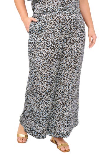 Wide-leg pants with a spotted pattern paired with gold open-toe sandals