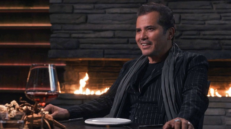 The Movie Star grinning at his table in The Menu