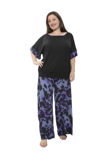 Person wearing a stylish loose black and patterned outfit, featuring a flowy top and wide-leg pants, suitable for a shopping context