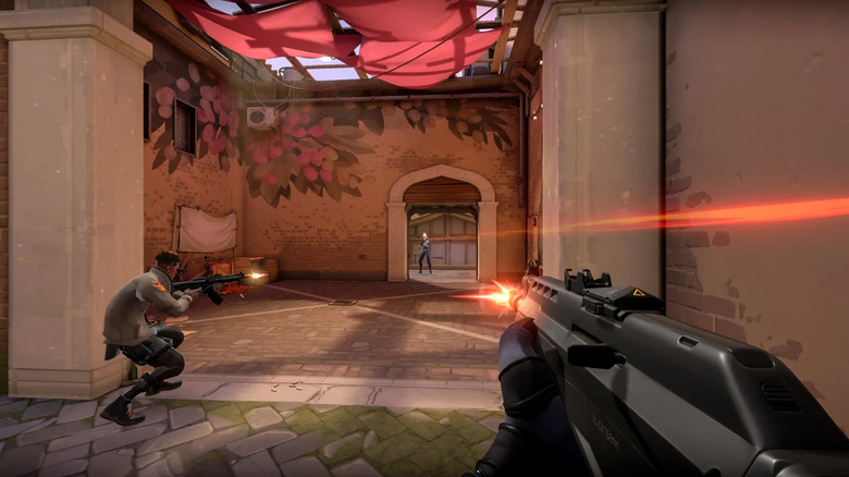 Two agents shoot at an enemy in a doorway in Valorant