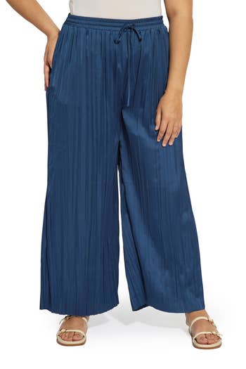 Person wearing wide-leg, pleated pants with a drawstring waist and sandals, suitable for casual outings