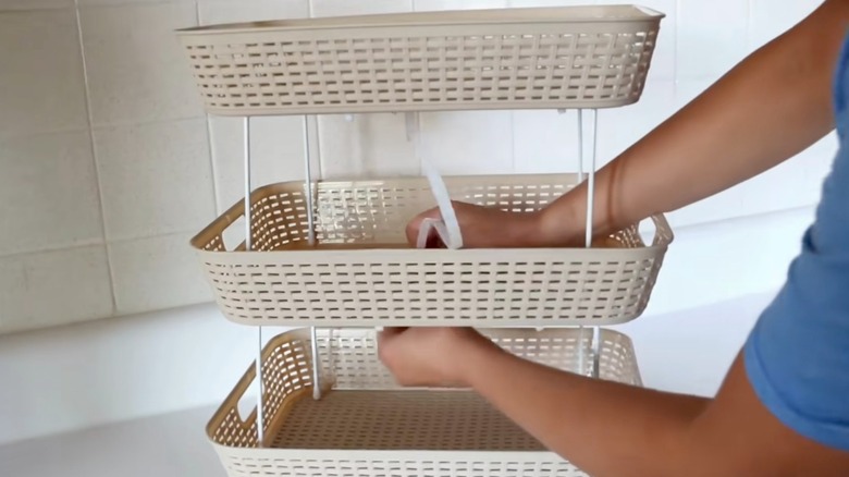 woman building tiered Dollar Tree organizer