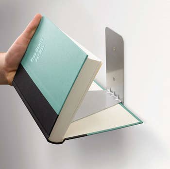 Book being attached to floating shelf