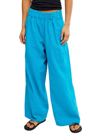 Person wearing loose-fitting pants with an elastic waistband and sandals