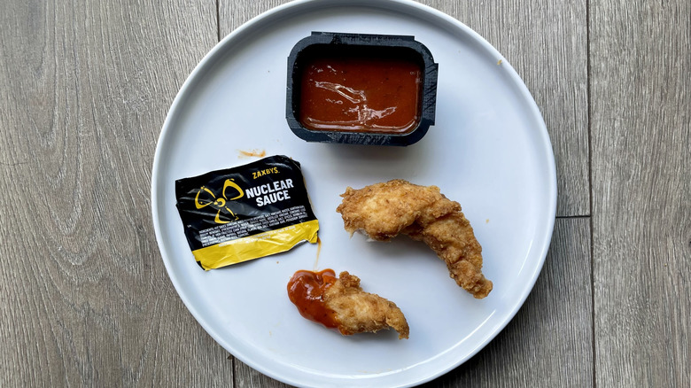 Chicken tender pieces with nuclear sauce on a plate