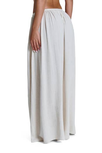 A person modeling a floor-length, loose-fitting skirt with a natural drape
