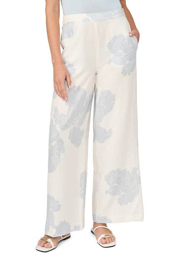 Wide-leg pants with a floral pattern, paired with white sandals