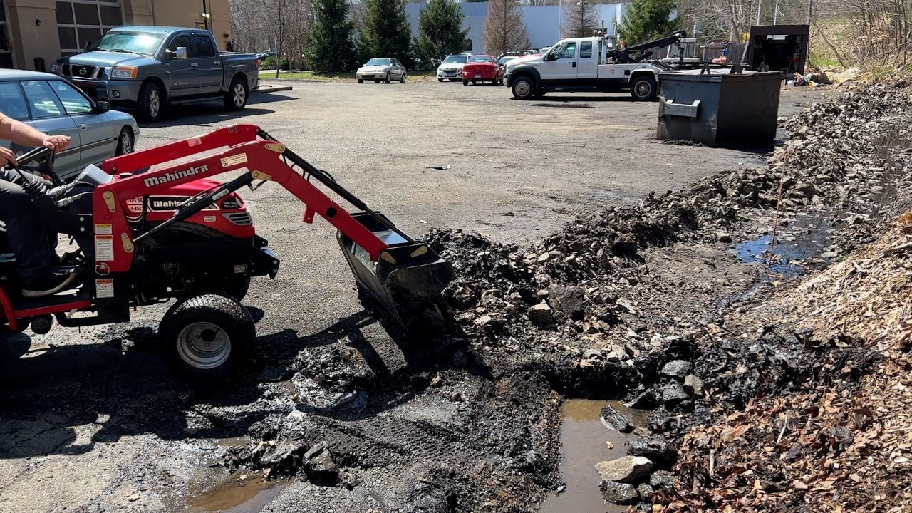 Digging a drainage ditch with a small tractor