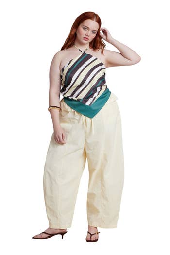 Person in a striped halter top and wide-leg pants models fashion; article is about shopping for summer styles