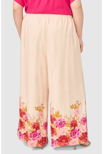 Wide-leg pants with a floral hem pattern, worn by a person