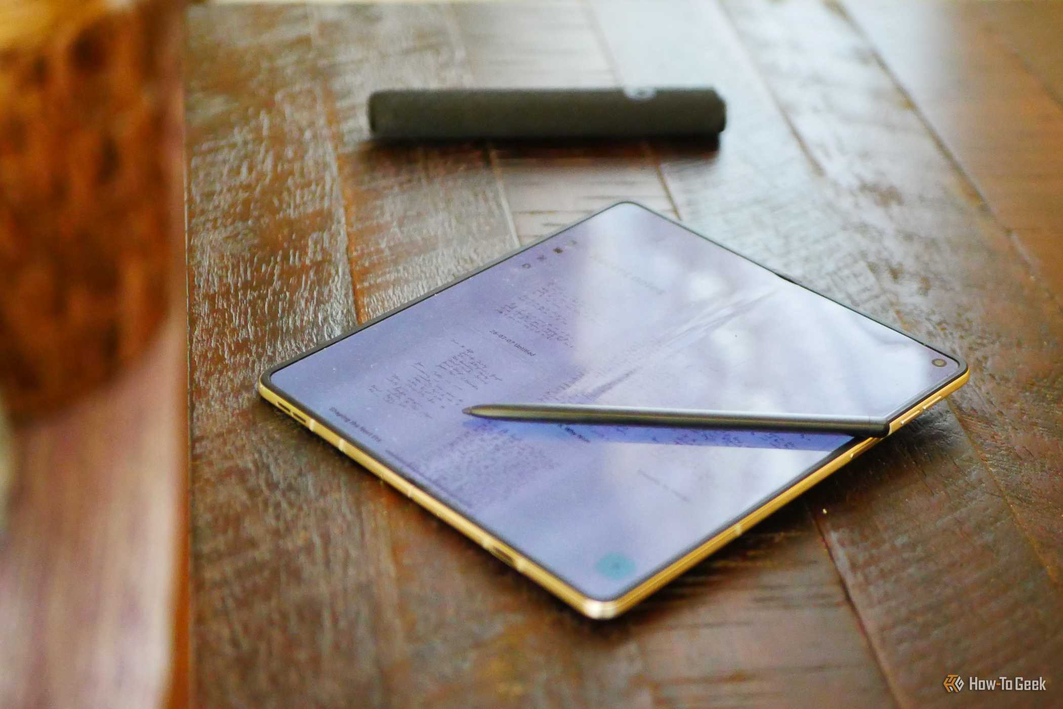 A Moto Pen Ultra on top of an unfolded Motorola Razr Fold displaying a notes app.