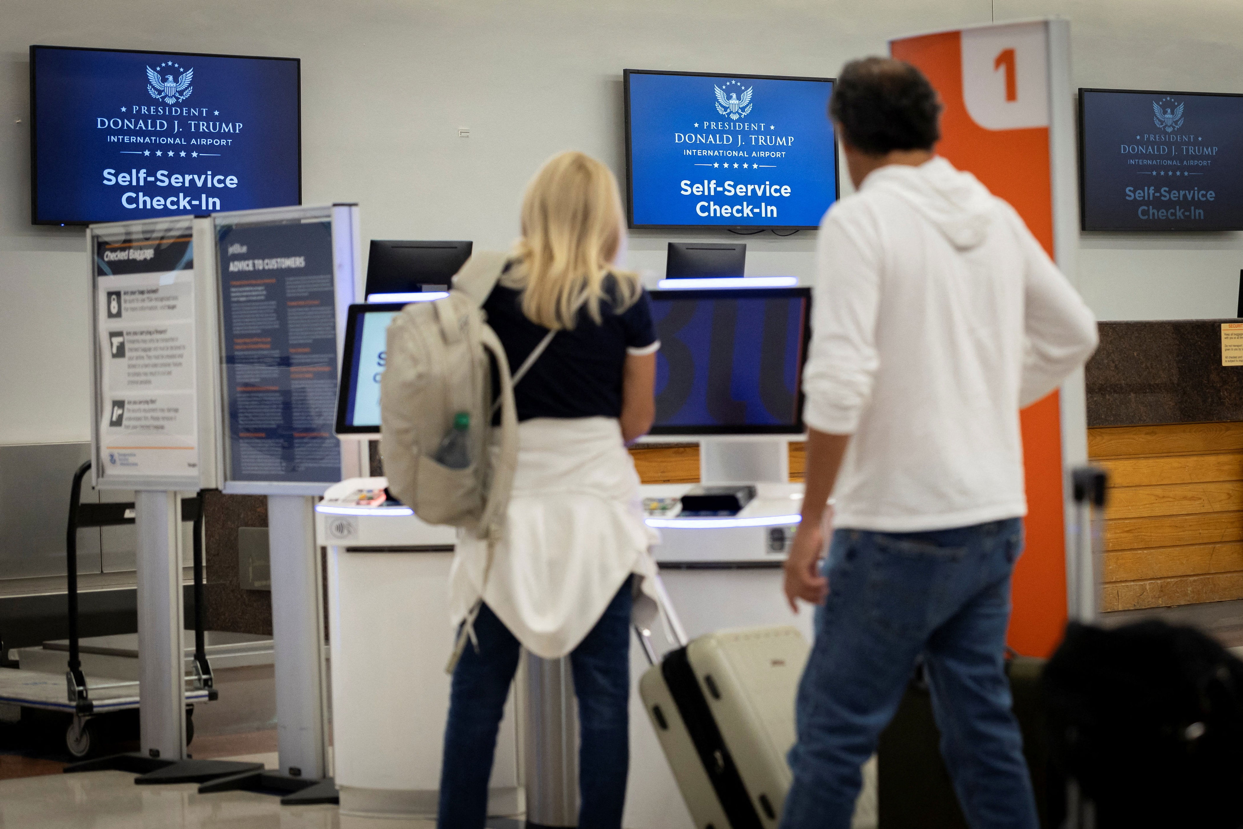 Passengers check in at the newly renamed President Donald J. Trump International Airport. / Marco Bello / REUTERS