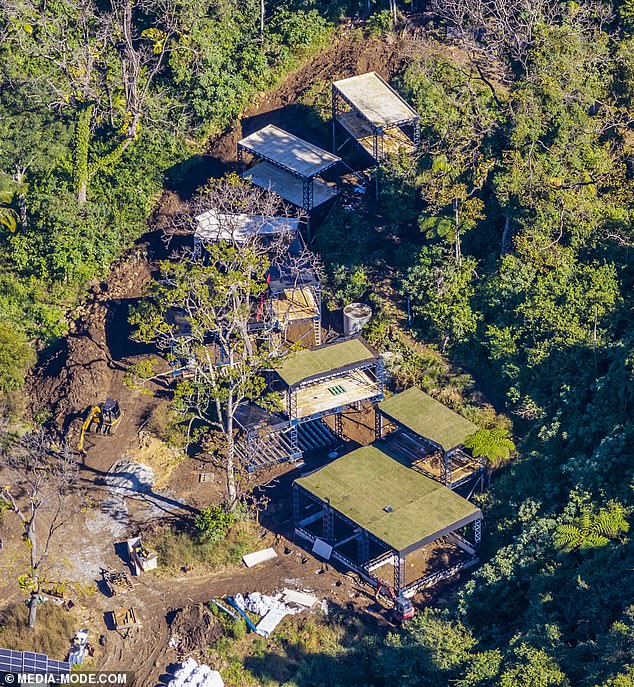 Another captures the wider work site, including an excavator, access tracks, stacked building supplies and solar panels positioned near the lower edge of the property