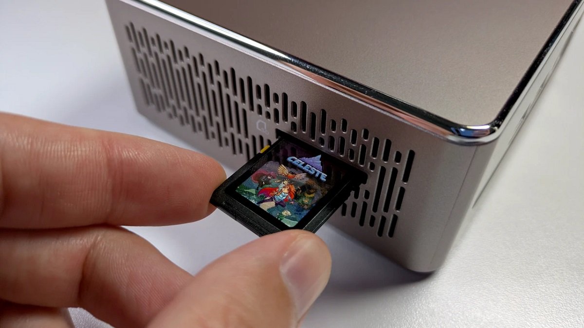 Someone inserting a video game cartridge into a PC slot