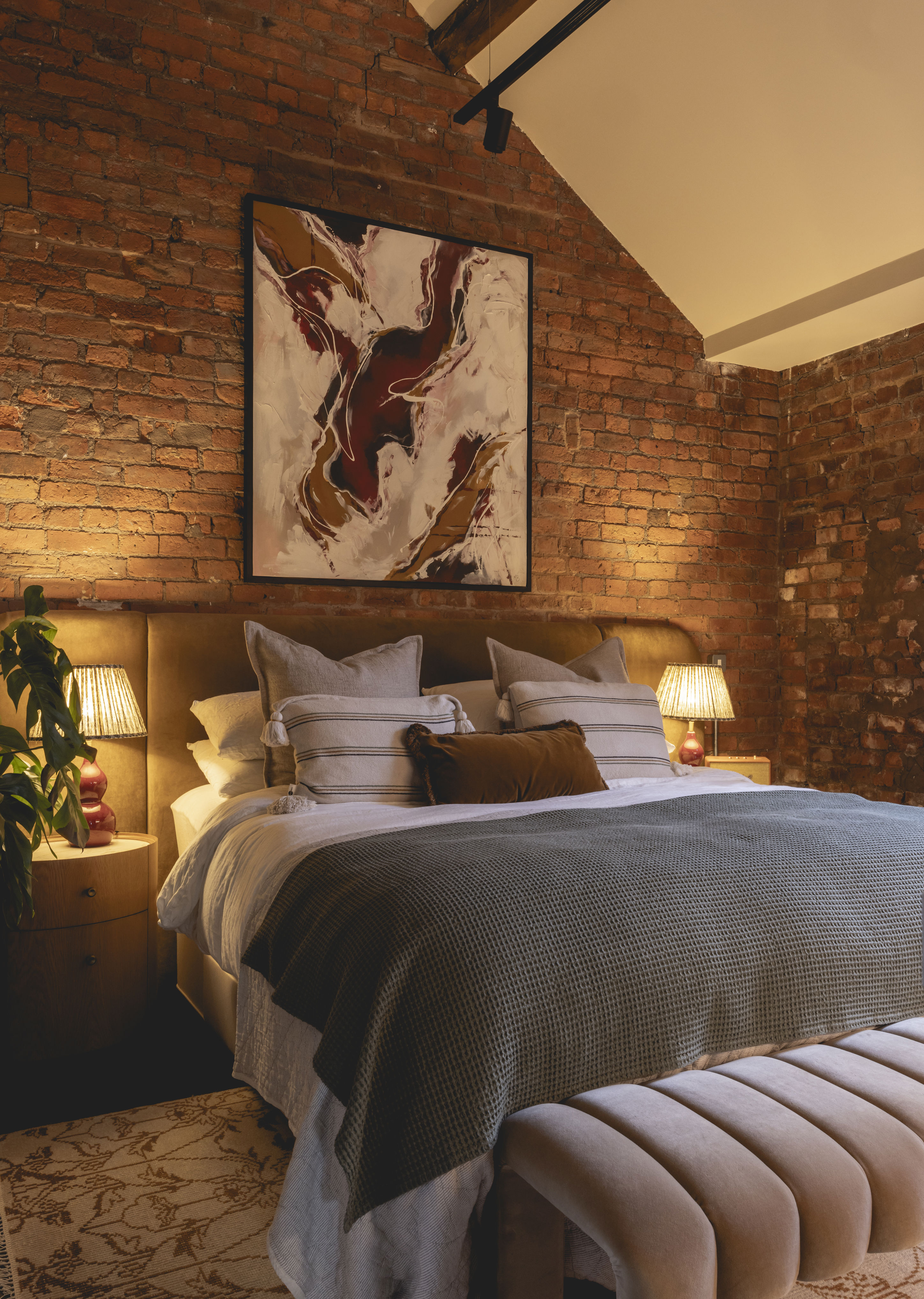 A contemporary bedroom with rustic exposed brick walls