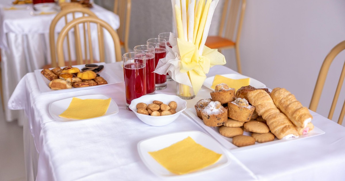 A beautifully arranged table with pastries, juice, and elegant napkin display, perfect for events.