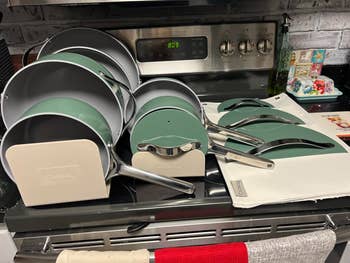 Cookware set with various pots and pans neatly arranged on a kitchen stove, showcasing modern design and stainless steel handles
