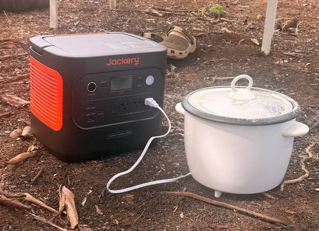 Portable power station charging a slow cooker outdoors, showcasing convenient, off-grid cooking abilities. Ideal for camping or power outages