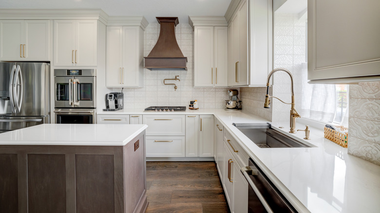 A luxury kitchen with large island and several expensive fixtures