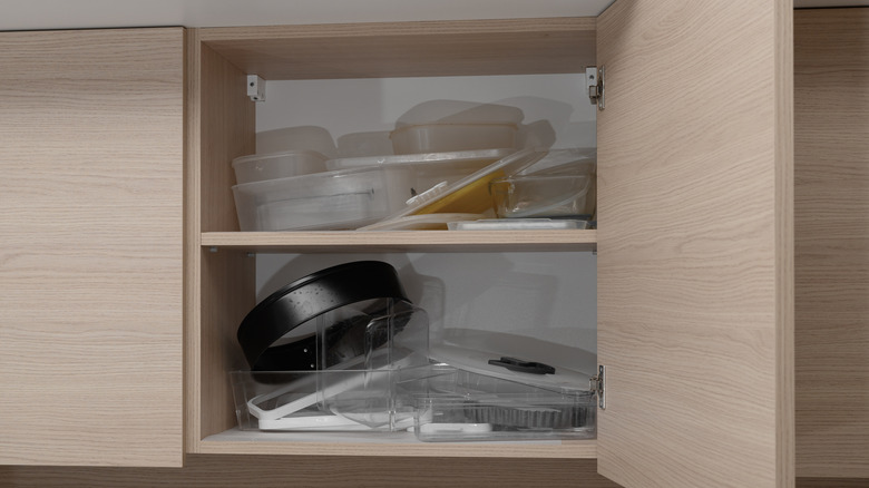 A cabinet cluttered with various kitchen items