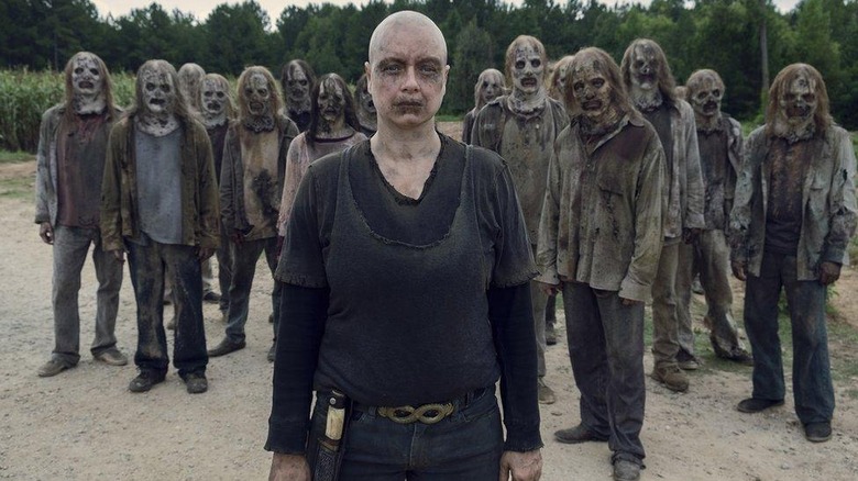 Alpha leading a squad of The Whisperers (people wearing zombie heads) in The Walking Dead