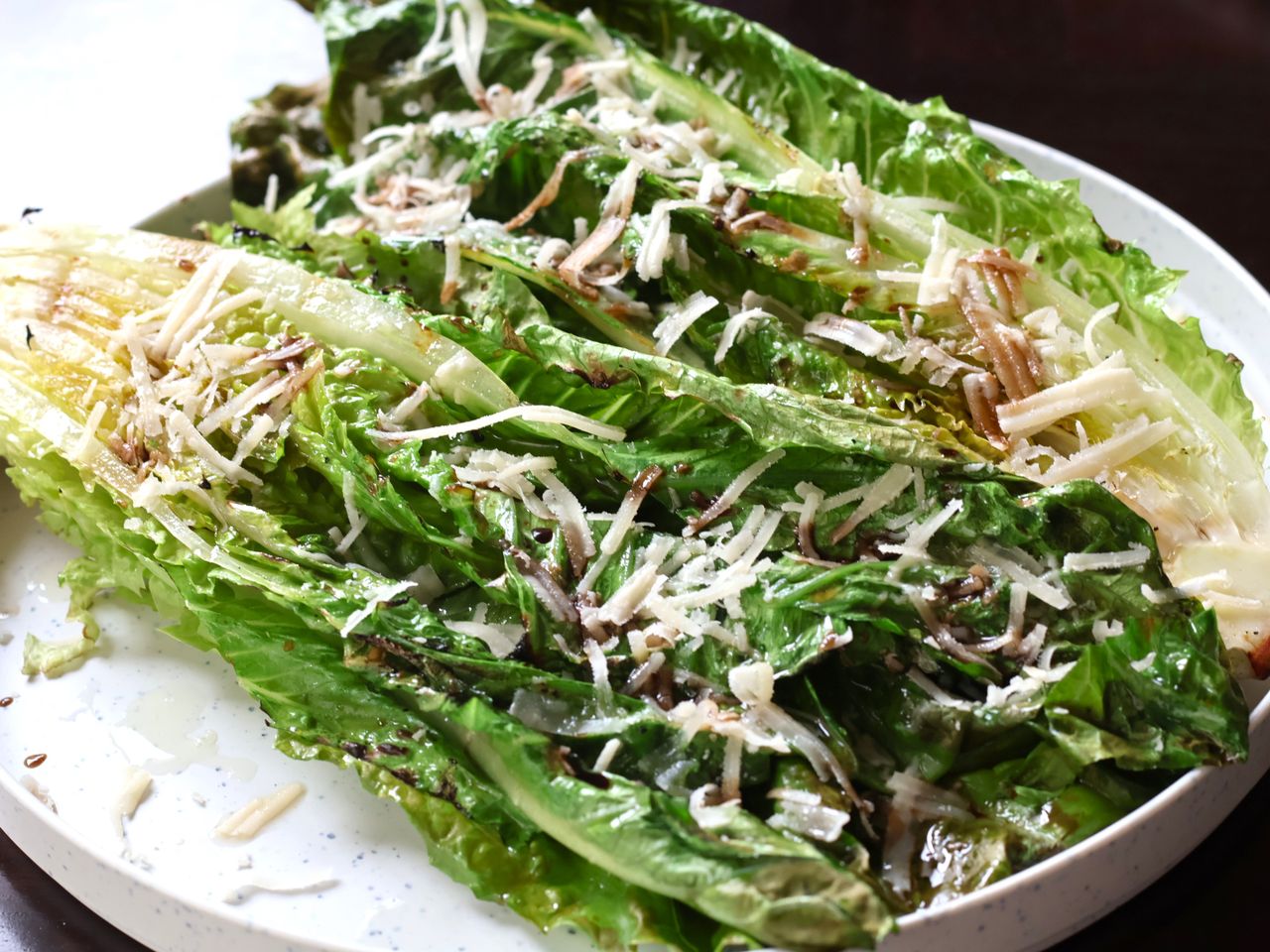 Grilled romaine topped with grated Parmesan cheese