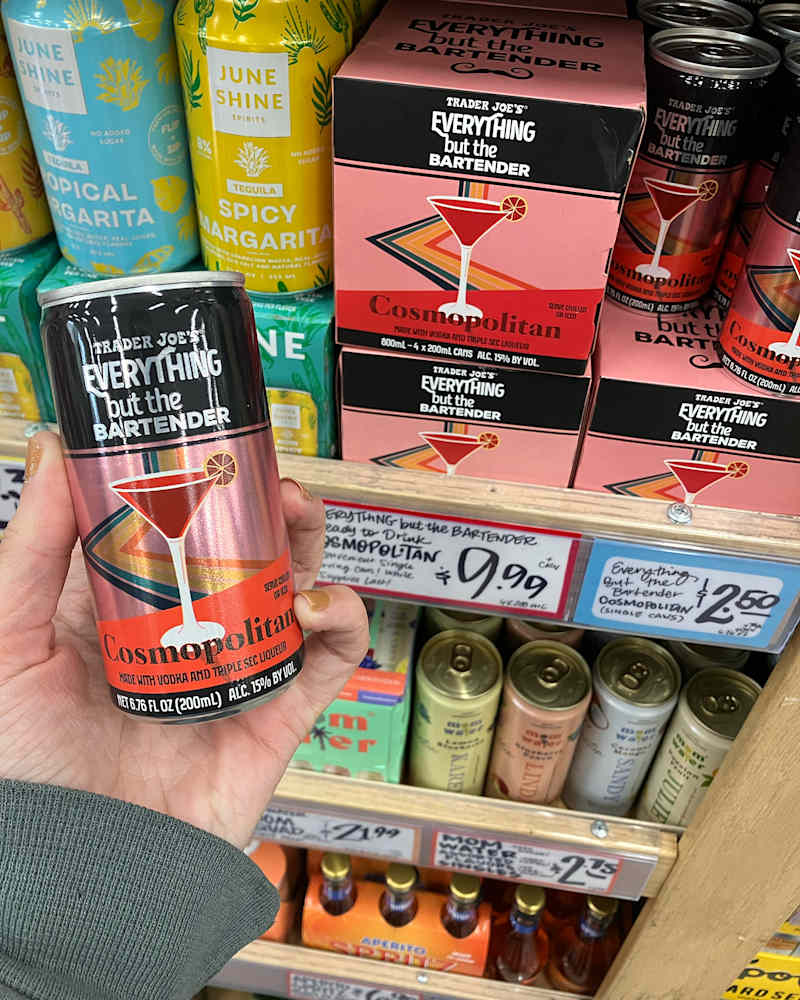 Someone holding can of Everything but the Bartender Cosmopolitan cocktail.