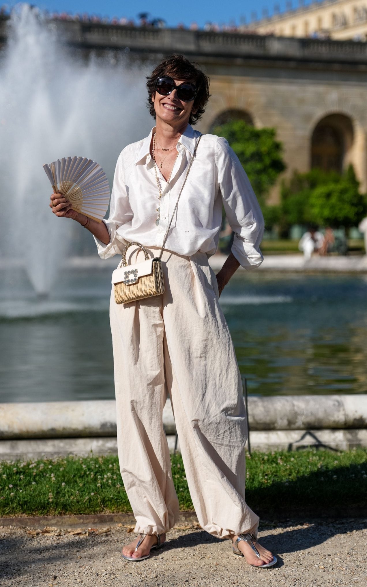 French supermodel Inès de La Fressange pairs a white, long-sleeved shirt with high-waisted trousers