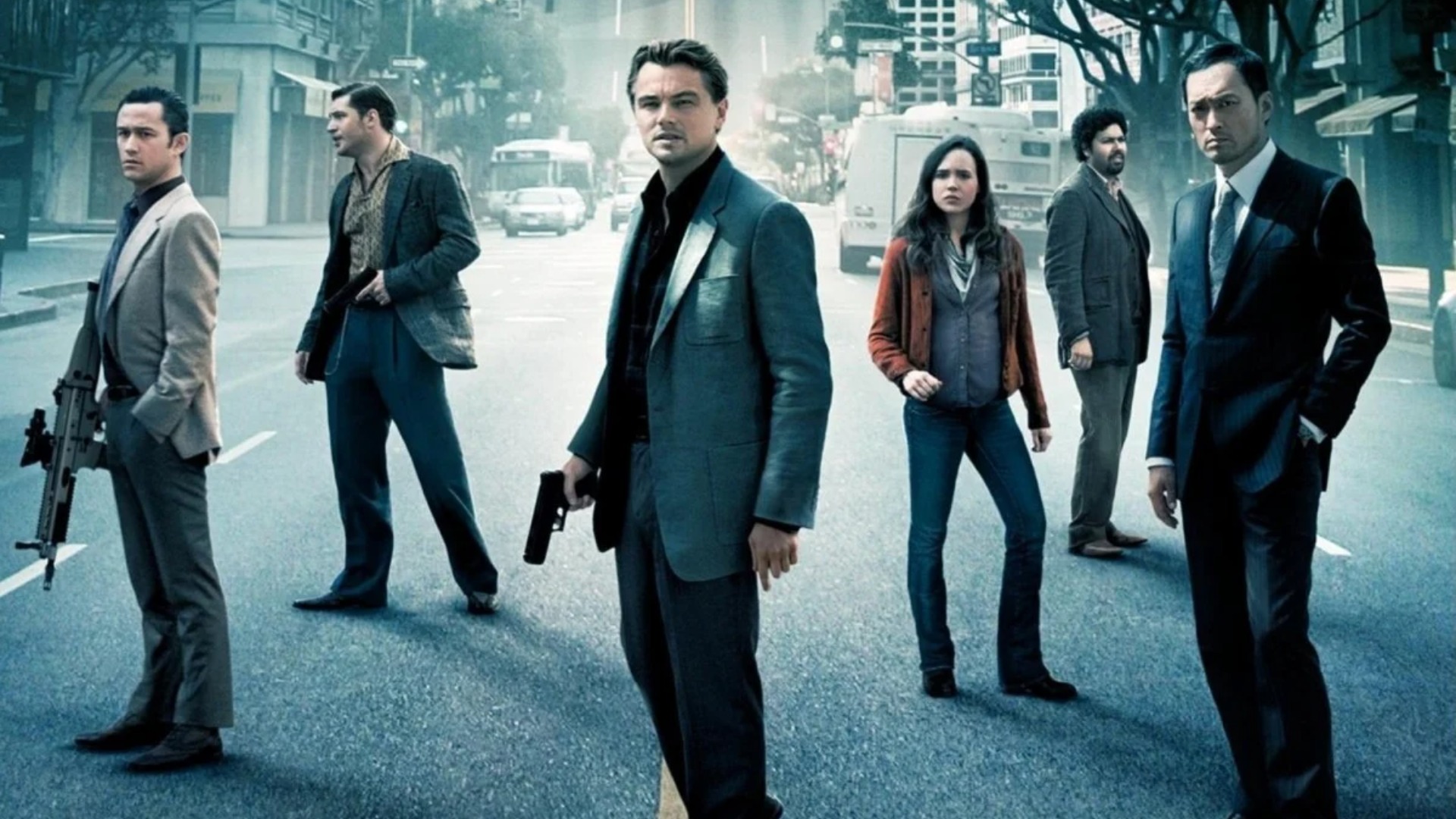 Leonardo DiCaprio as Dom Cobb standing in front of a group of people for the poster of the Christopher Nolan movie, Inception.