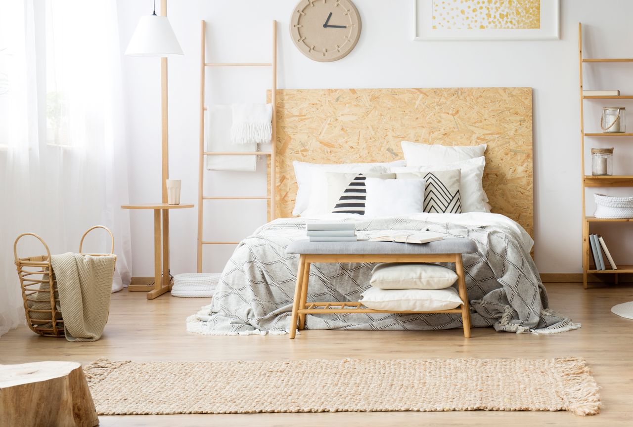 A naturalstyled bedroom with a bed wooden furniture textiles and decorative elements