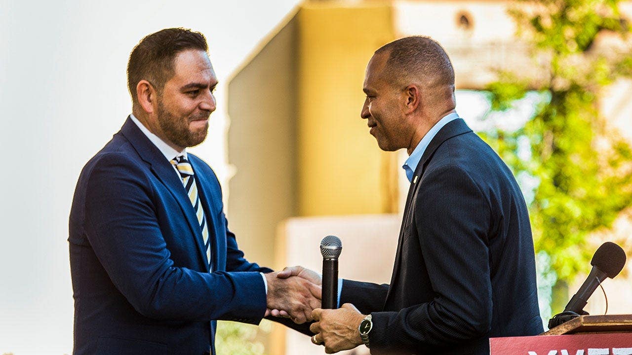 Hakeem Jeffries and Gabe Vasquez shake hands at a news conference.