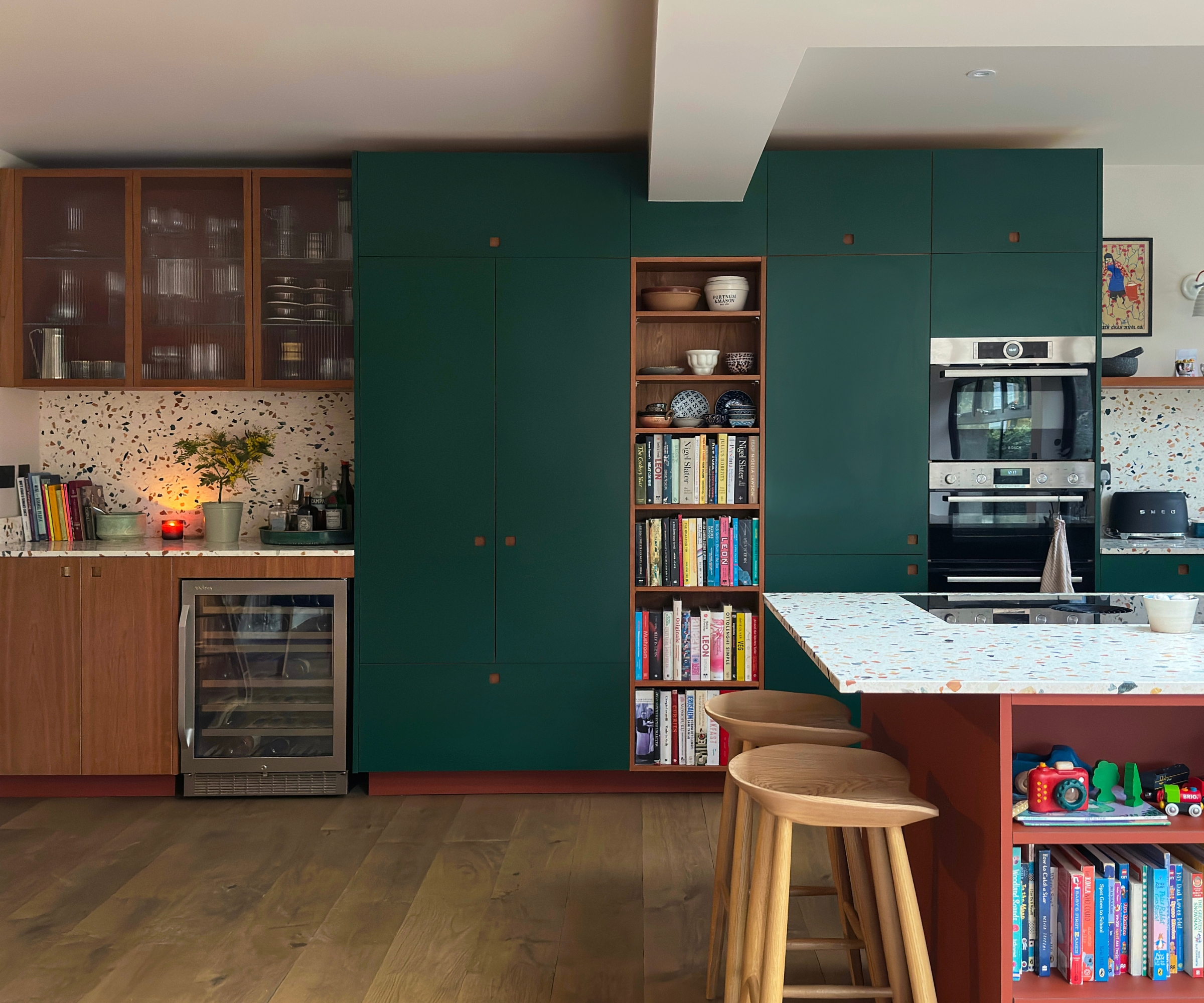 A large kitchen with a mix of cherry wood cabinets and dark green cabinets