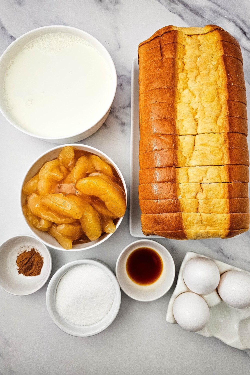 Apple pie bread pudding ingredients: brioche loaf, milk, eggs, sugar, cinnamon, vanilla and apple pie filling