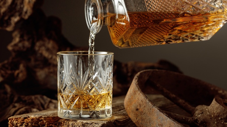 Liquor poured into glass with rustic surroundings