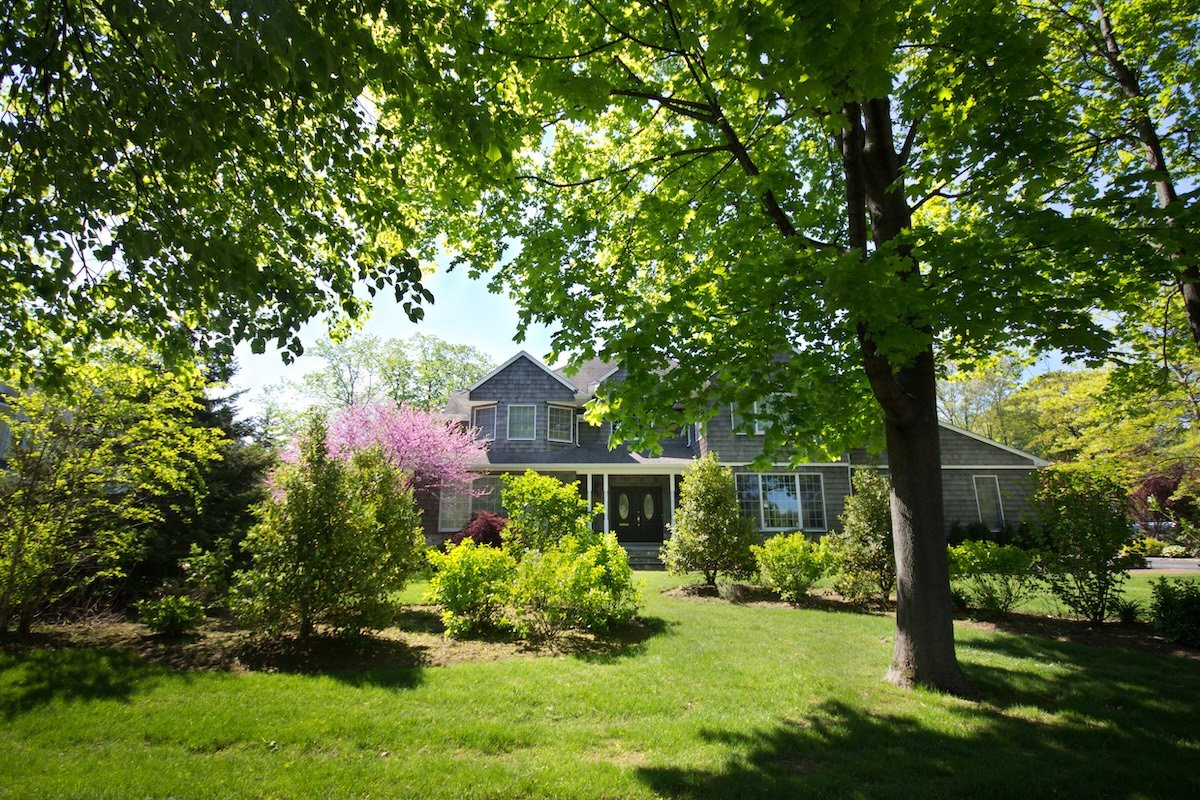 Beautiful two-story home shaded by mature trees.