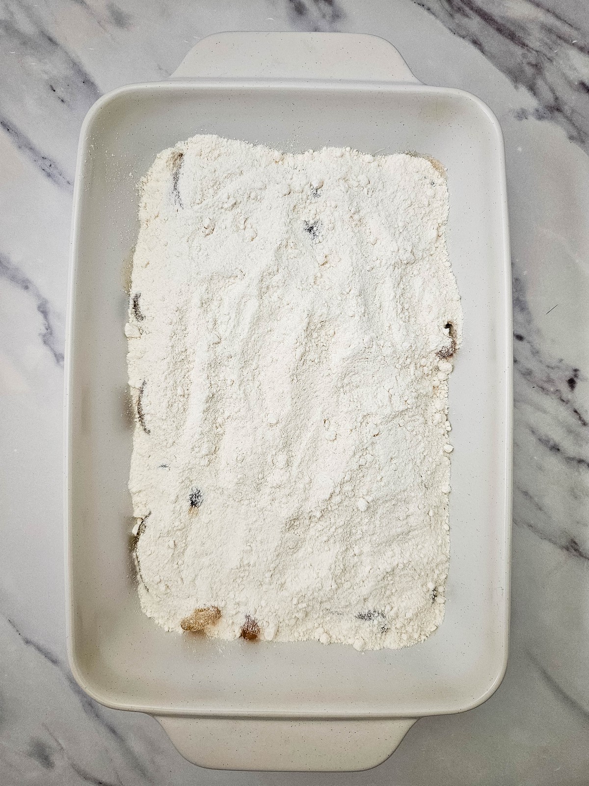 Dry yellow cake mix spread evenly over apple pie filling in a baking dish