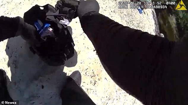An officer reaches into his medical kit to get a tourniquet as first responders attempted to save Clark's life