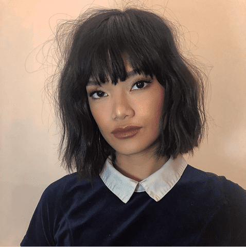 A woman with a chin-length bob haircut with fringe