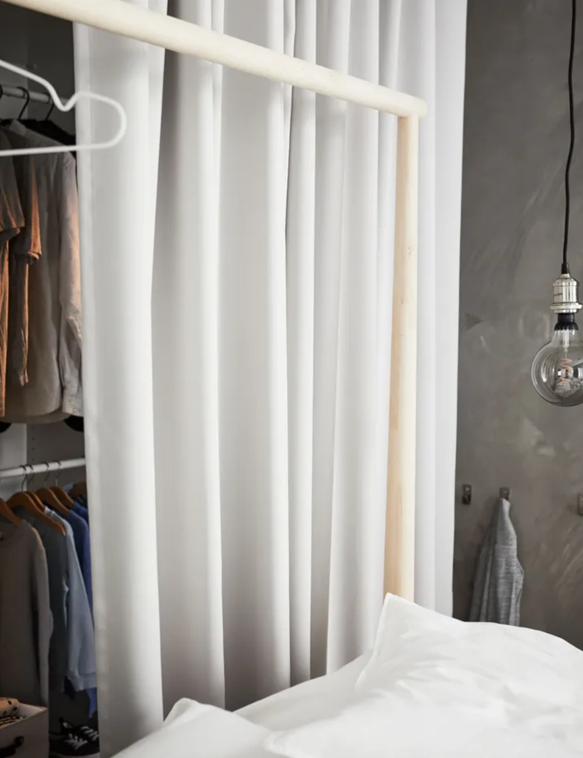 Modern bedroom with open closet, covered in white curtain, bed with white linen
