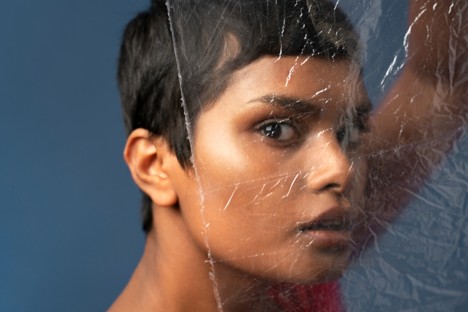 Woman looking through cracked plastic