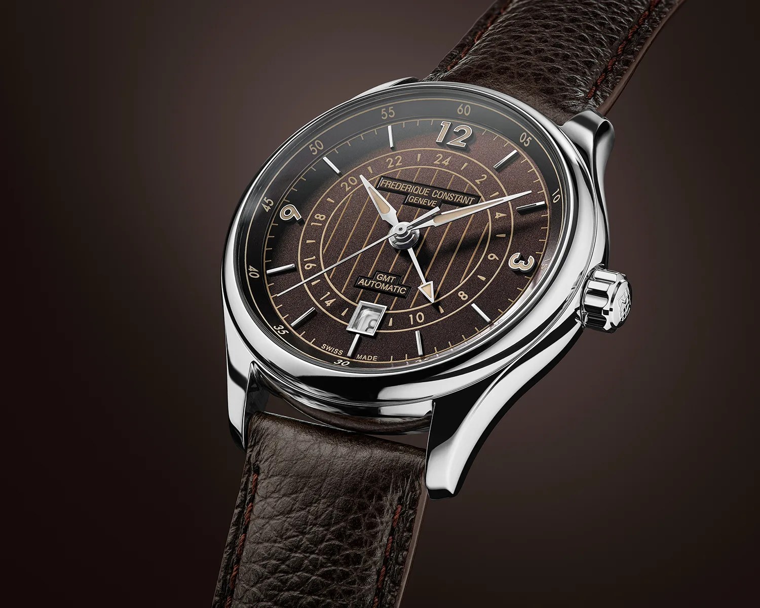 Polished silver watch with brown textured dial, gold-tone markings, date window, and dark brown leather strap.
