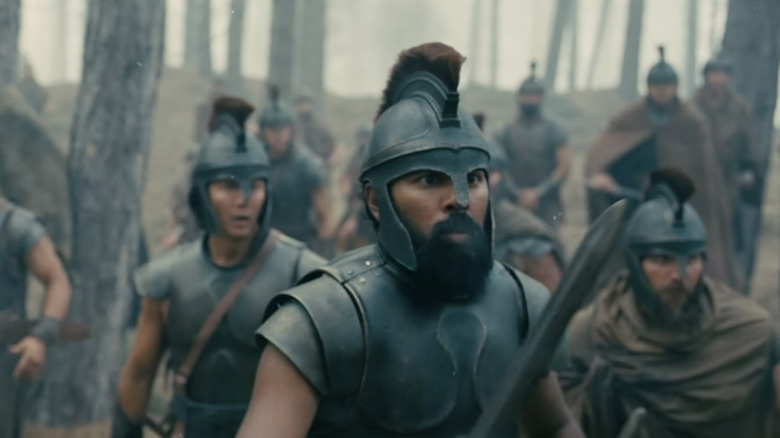 Eurylochus holds his sword stand with soldiers in a forest in "The Odyssey" (2026)