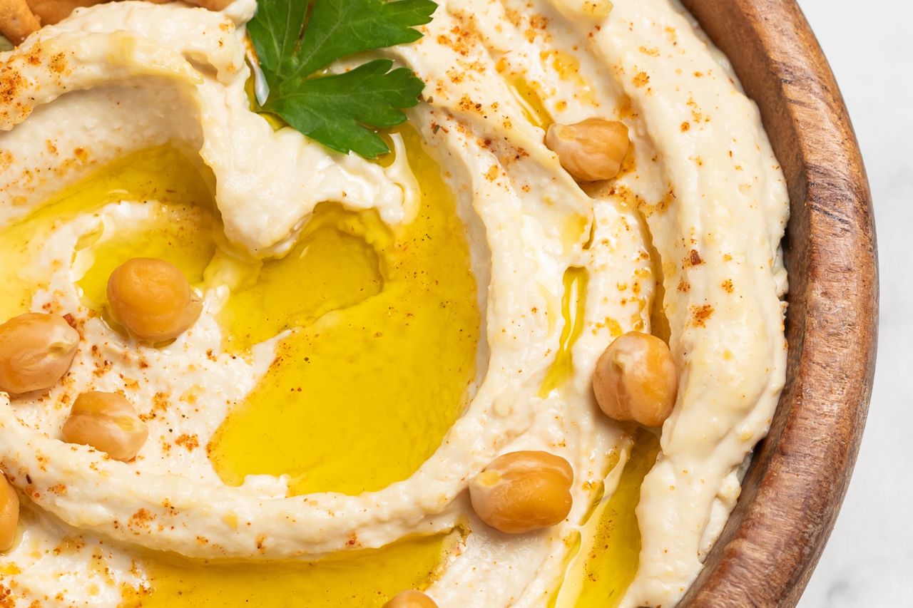 A bowl of hummus garnished with chickpeas and parsley
