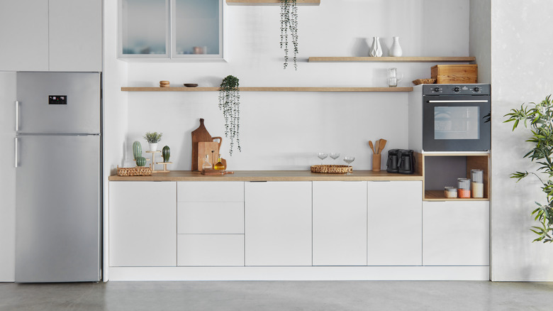 Wide-angle shot of a very white kitchen with gray flooring