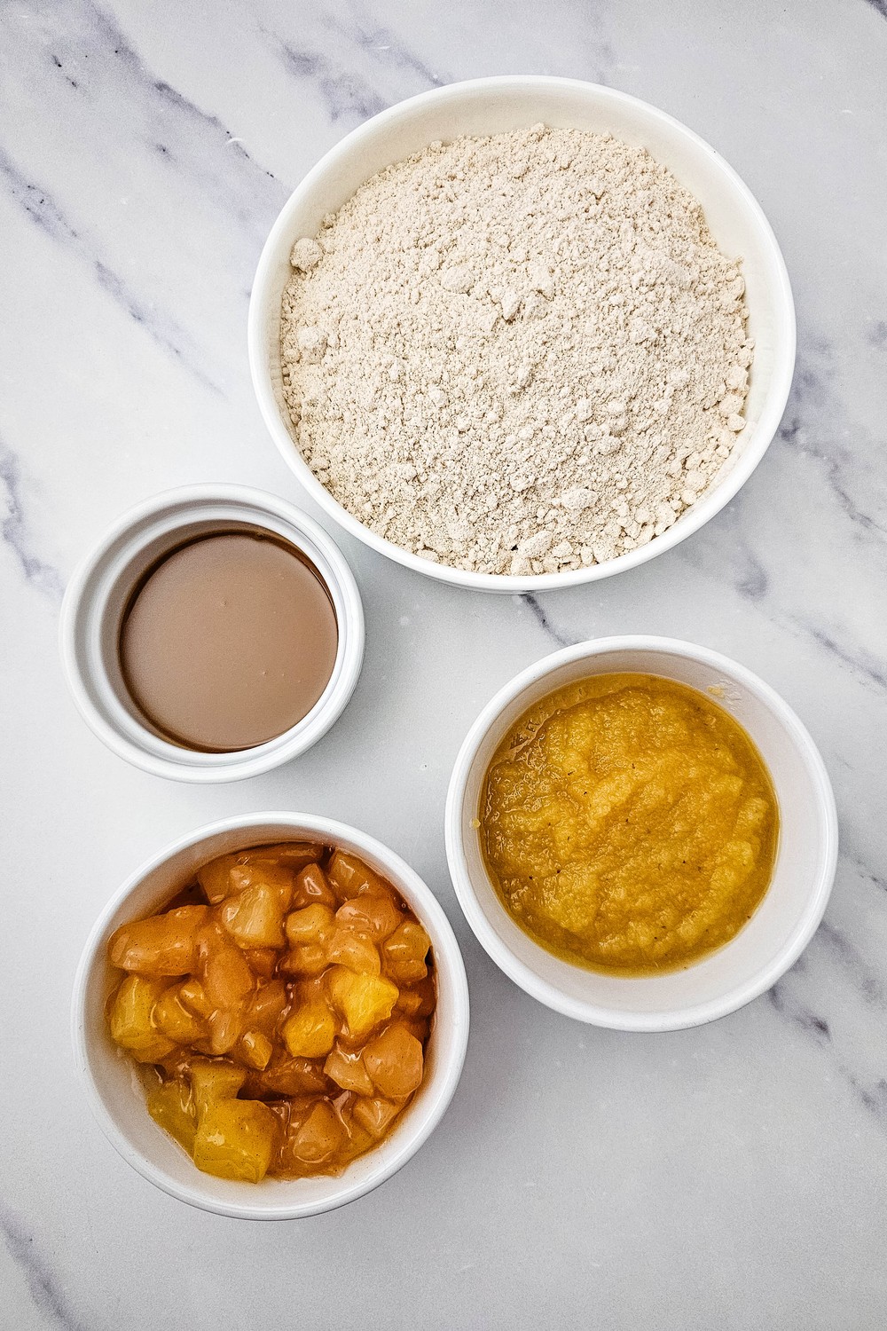 Four ingredients for apple pie filling cookies: spice cake mix, applesauce, apple pie filling and caramel sauce