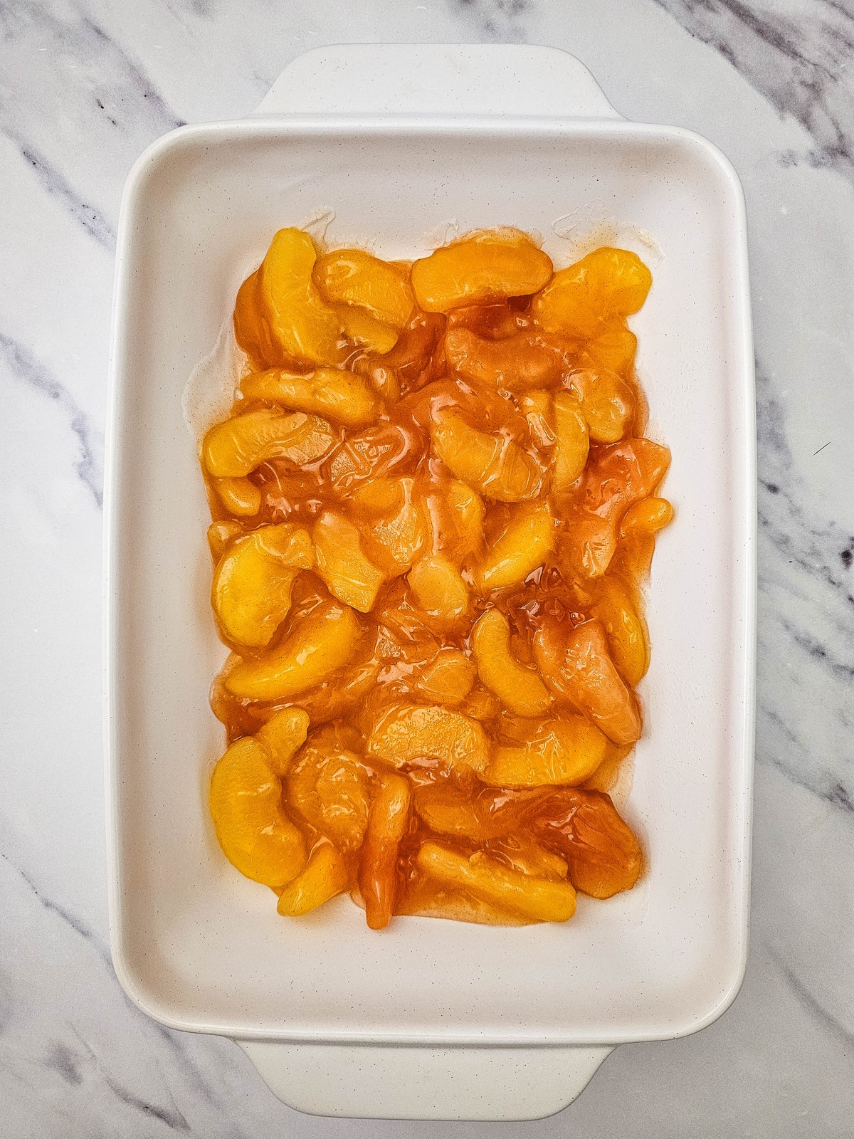 Apple pie filling spread evenly in a white 9x13 baking dish