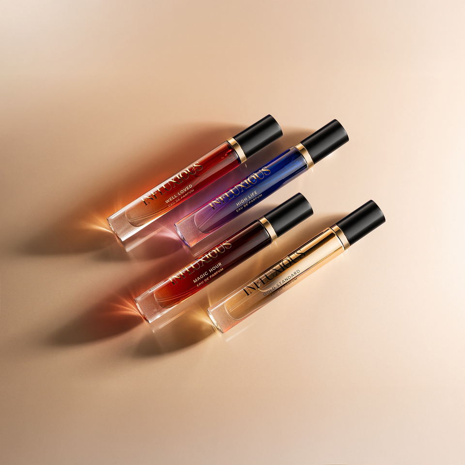 A set of four perfume bottles arranged in a diagonal line on a light background