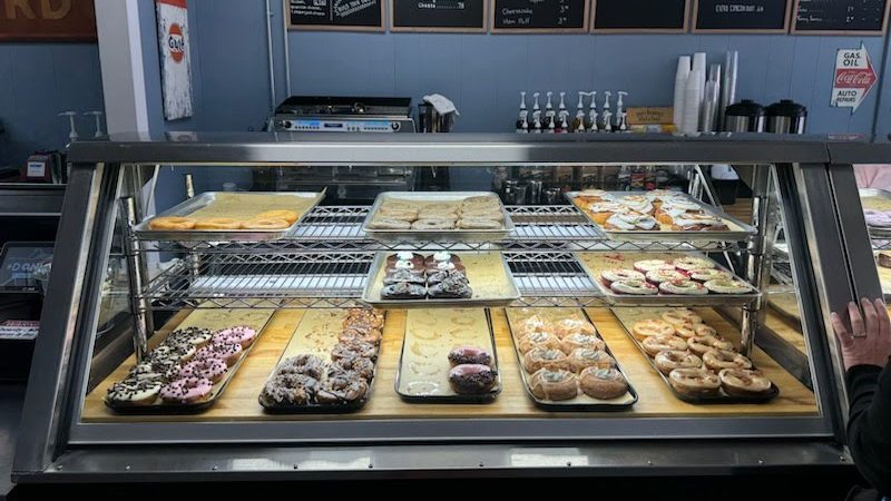 A display case filled with pastries at a donut shop in Commerce, Georgia.