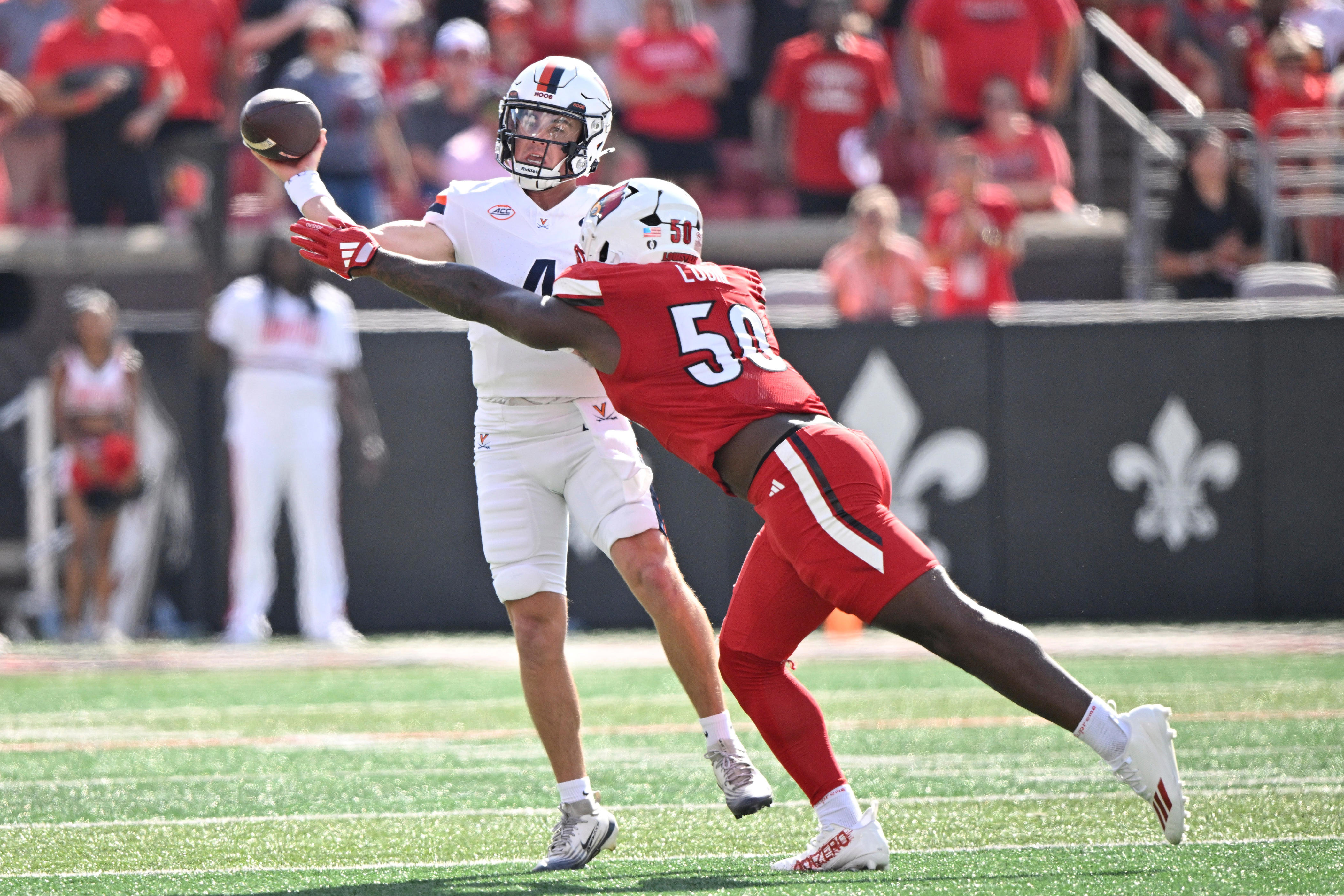 Oct 4, 2025; Louisville, Kentucky, USA; Virginia Cavaliers quarterback Chandler Morris (4) looks to pass against Louisville Cardinals defensive lineman Clev Lubin (50) during the first quarter at L&N Federal Credit Union Stadium. Mandatory Credit: Jamie Rhodes-Imagn Images