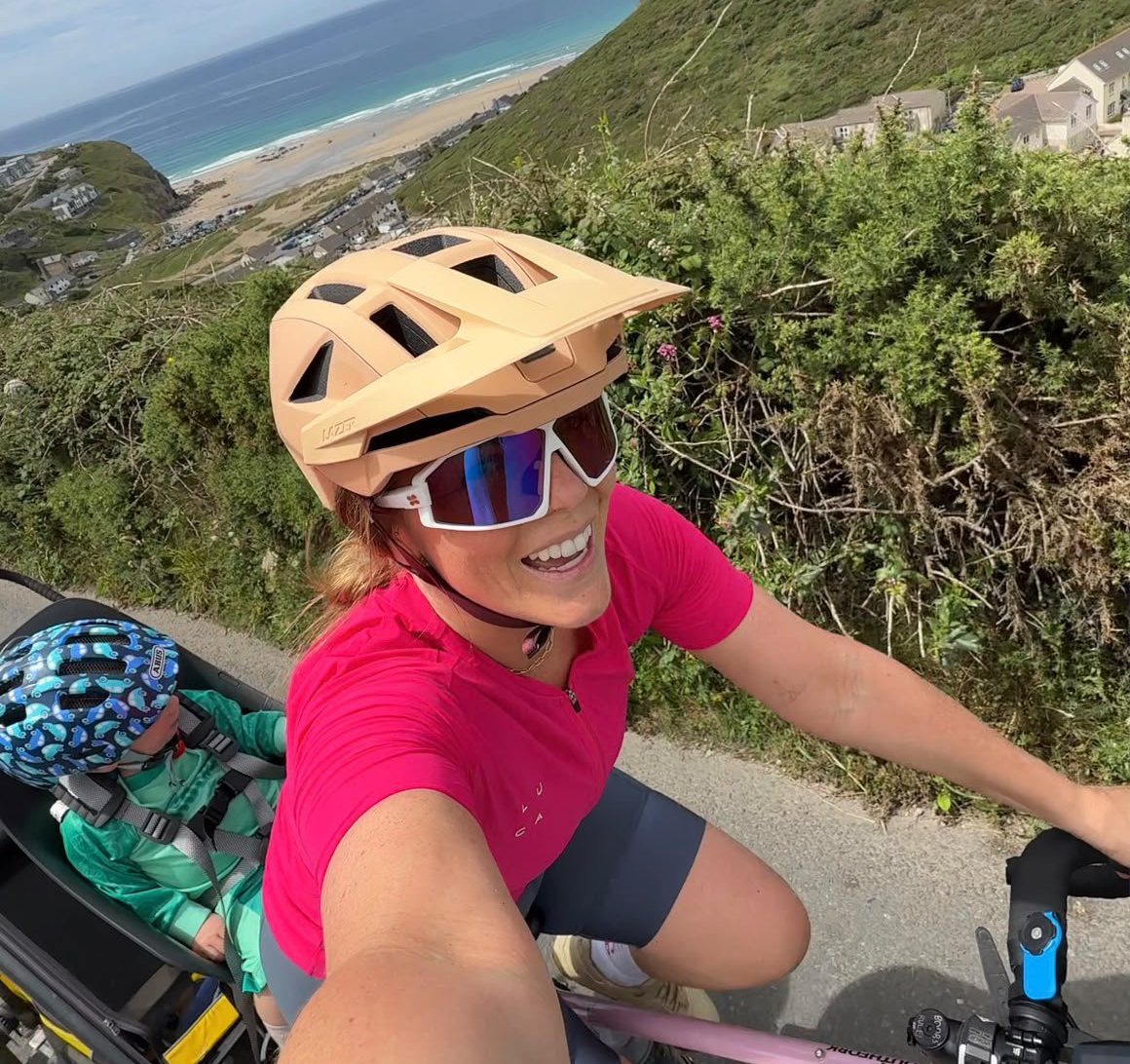 Ro her bike with the sea behind her